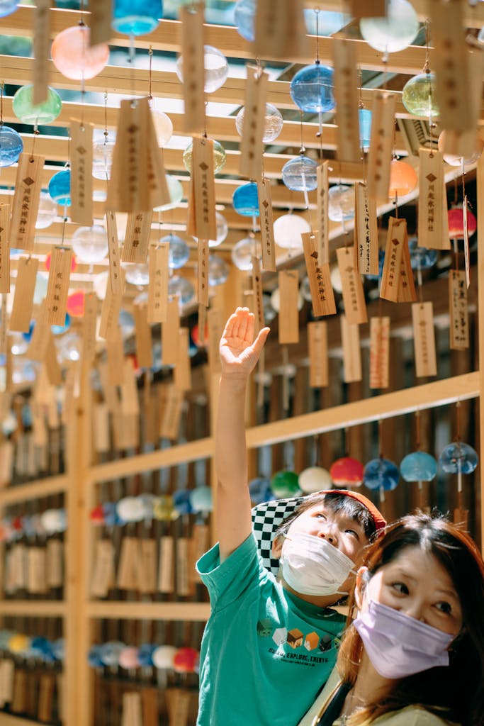 A mother and son enjoy a colorful Japanese festival with hanging ornaments and traditional ambiance.