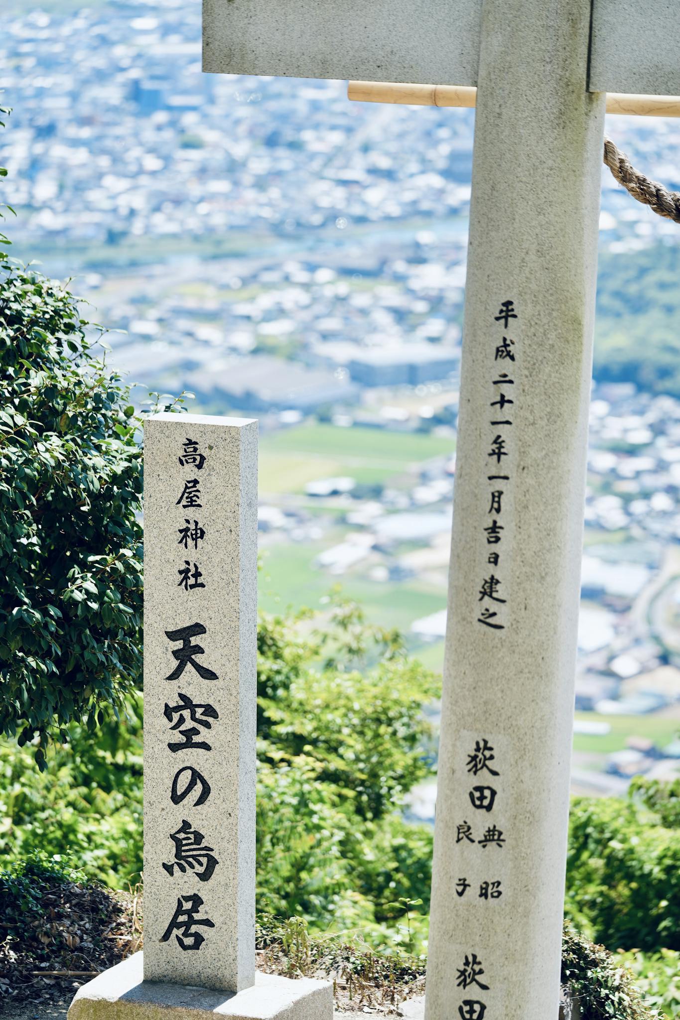 A traditional Japanese stone Torii gate overlooking a serene landscape.